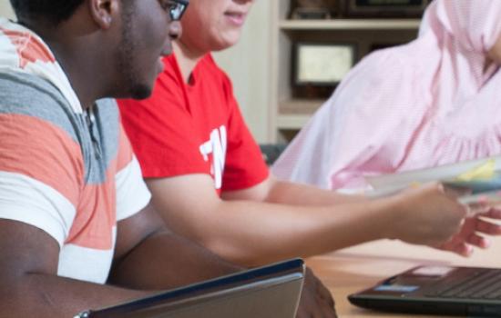 Honors College students working together in front of a laptop computer