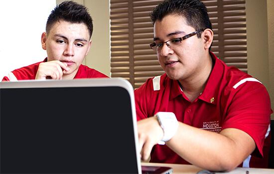two UH students at a laptop working on a data project