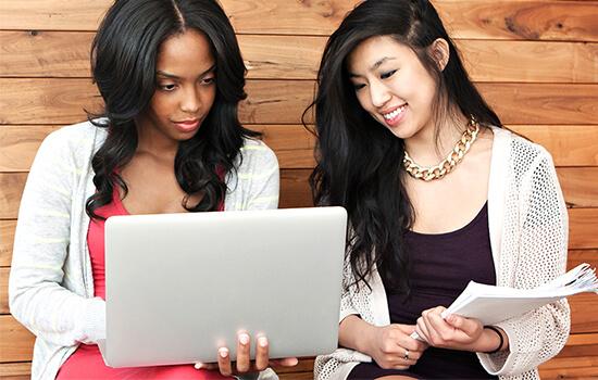 two UH students with laptop reviewing a project